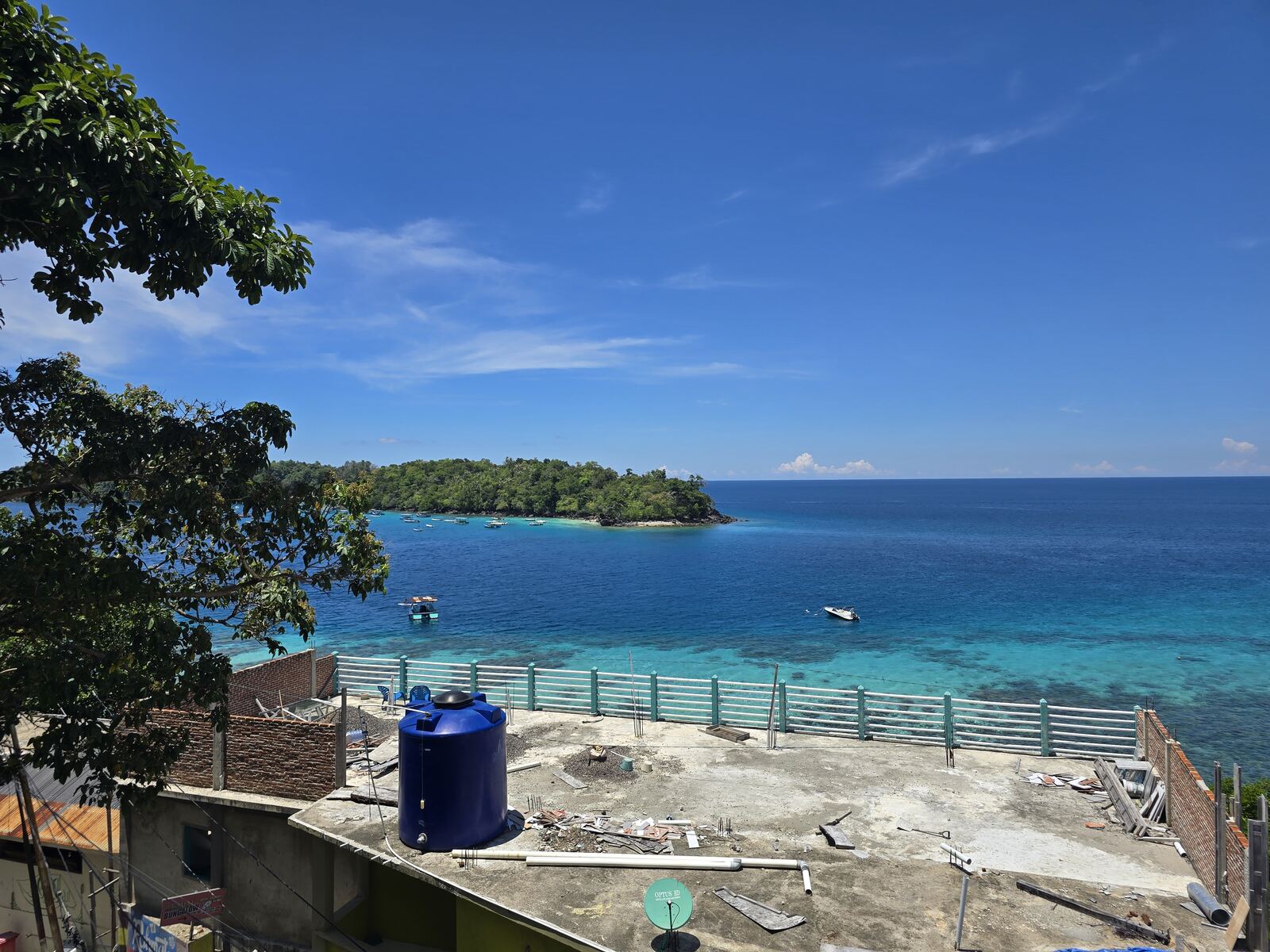 Pemandangan pantai dan pulau dari Iboih Bungalow, dibingkai pepohonan