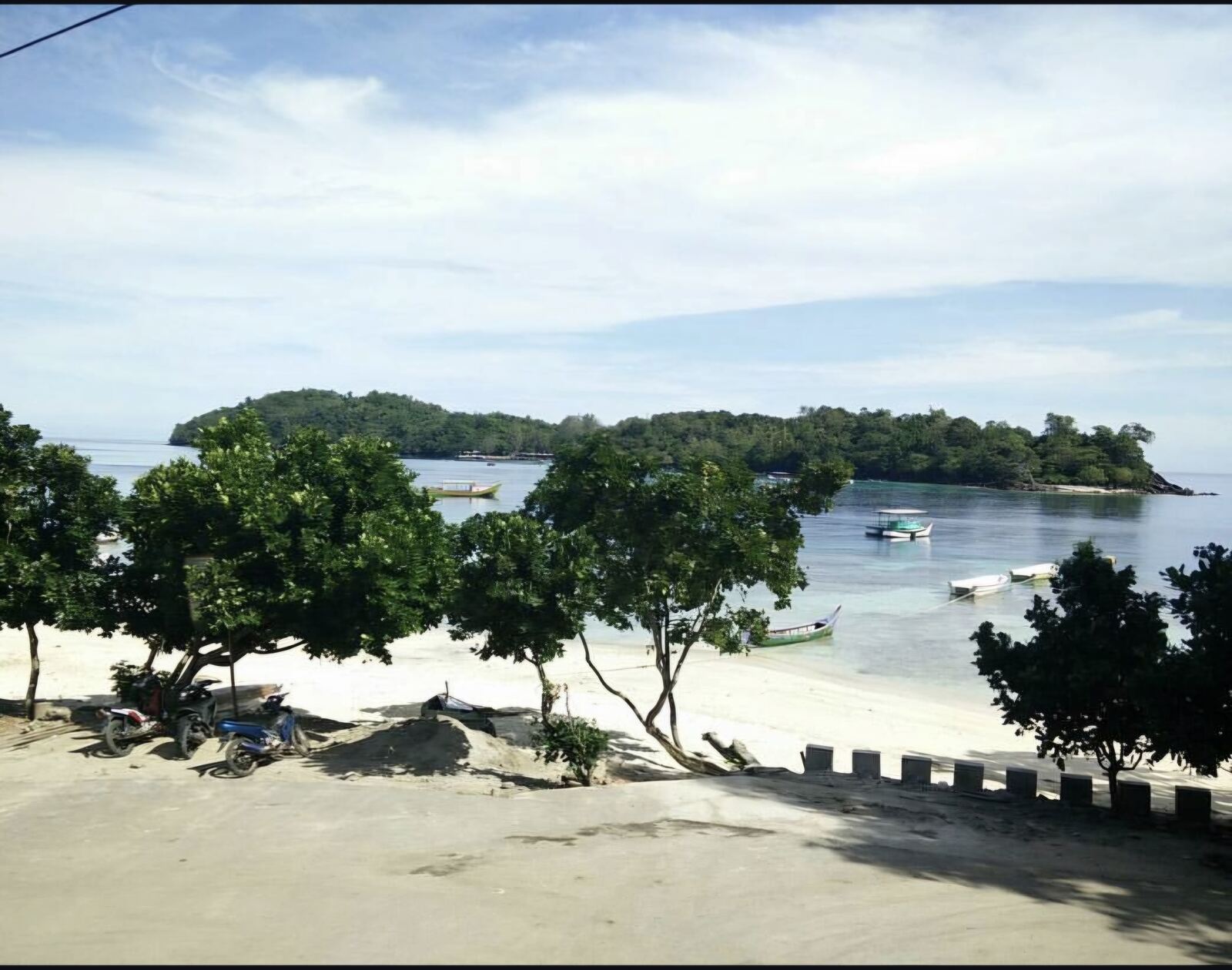 Pantai Iboih dengan perahu longtail dan pulau-pulau kecil